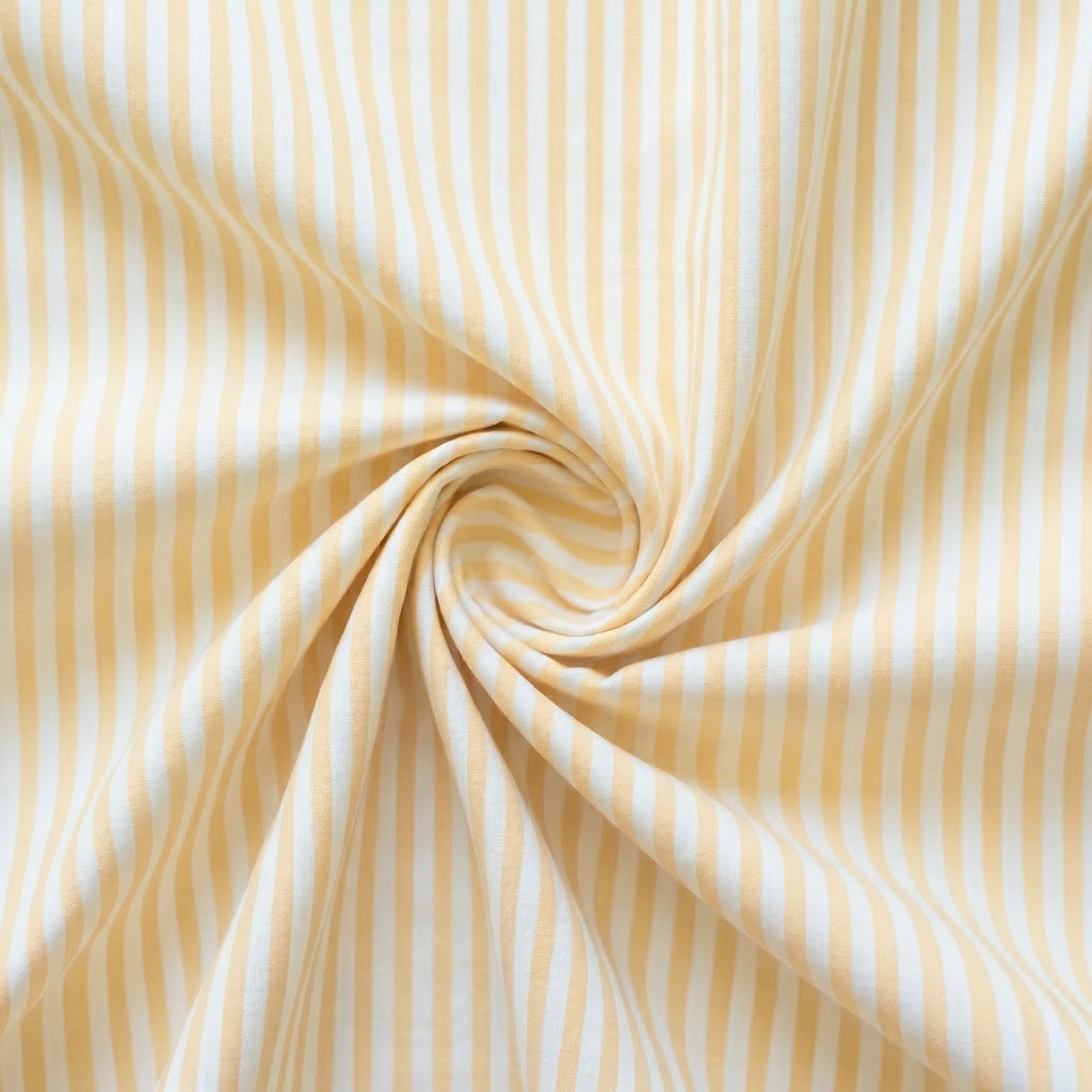 Close-up of yellow and white striped fabric in a swirl.