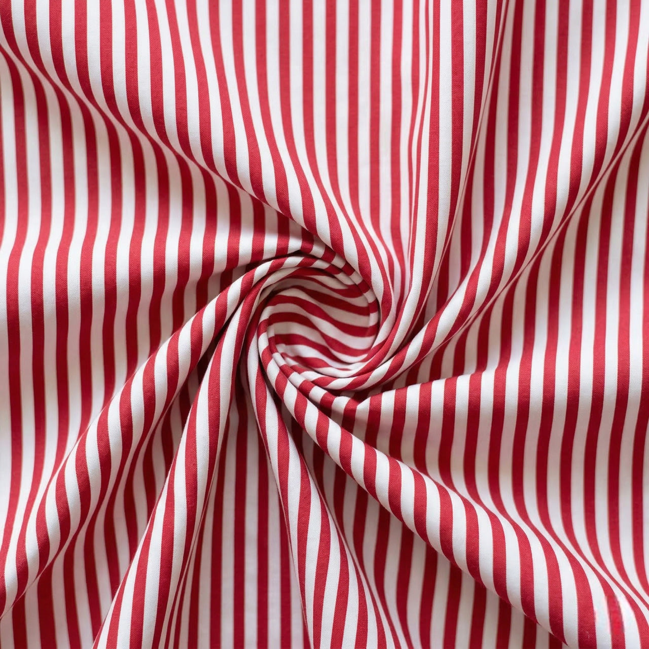 Red and white striped fabric in a swirl pattern
