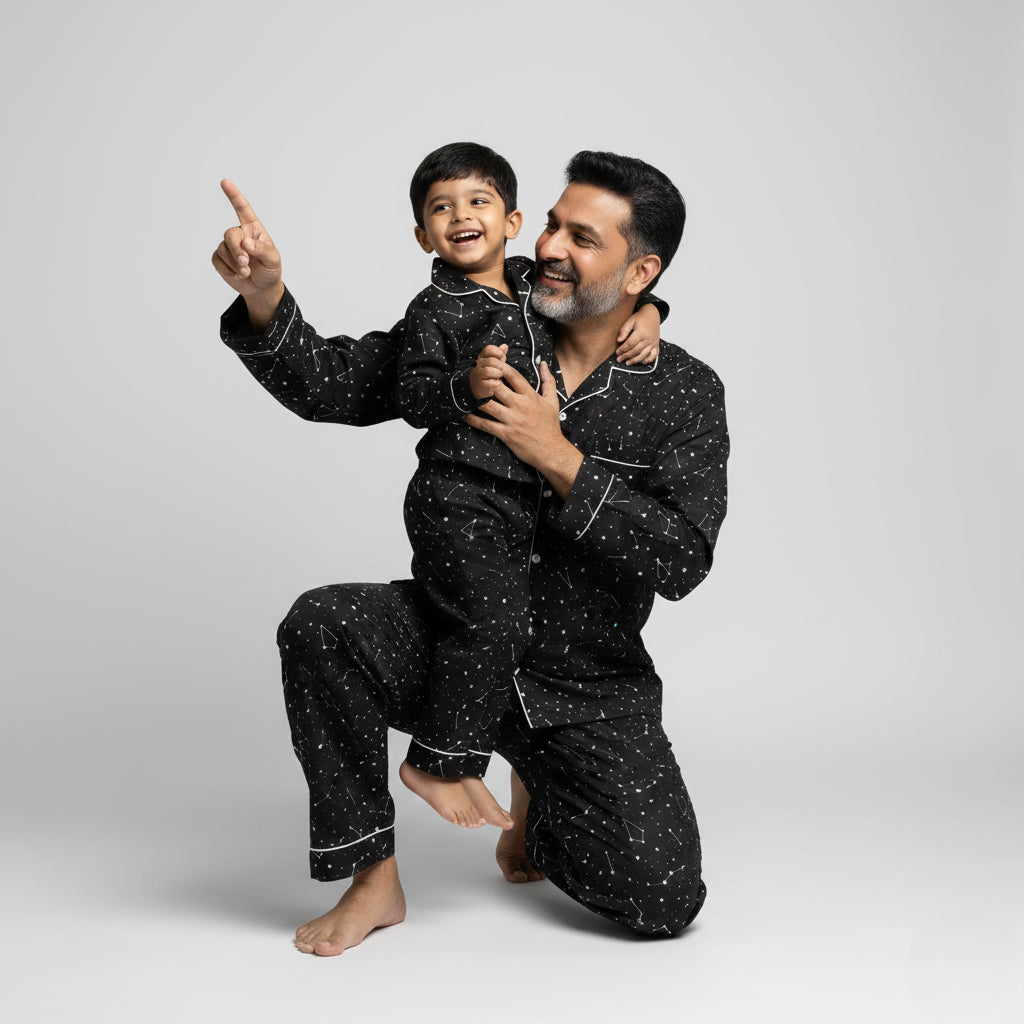 Father and son wearing constellation print matching pajamas, star-themed coordinated nightwear.