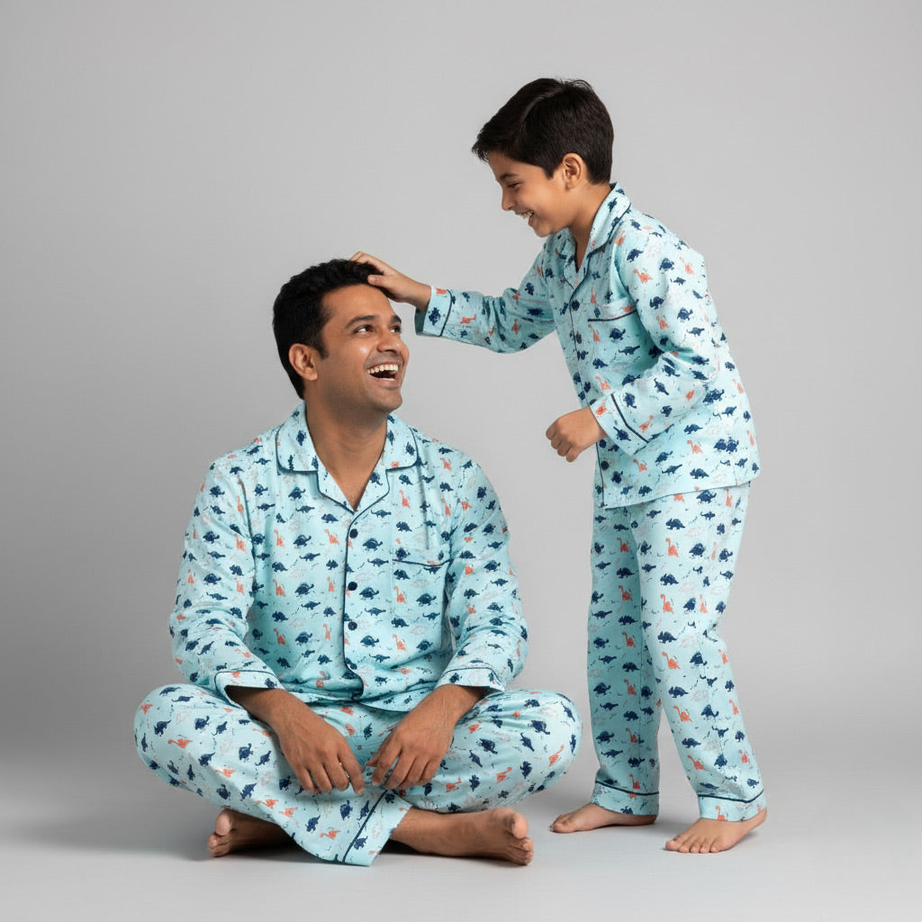 Father and son in dinosaur print matching pajama set, playful green coordinated nightwear.