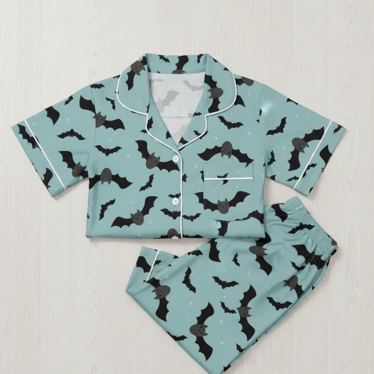 Teal pajama set with black bat pattern on a light gray background