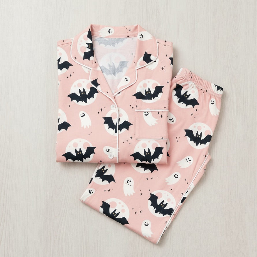 Pink pajama set with bat and ghost pattern on a light gray background