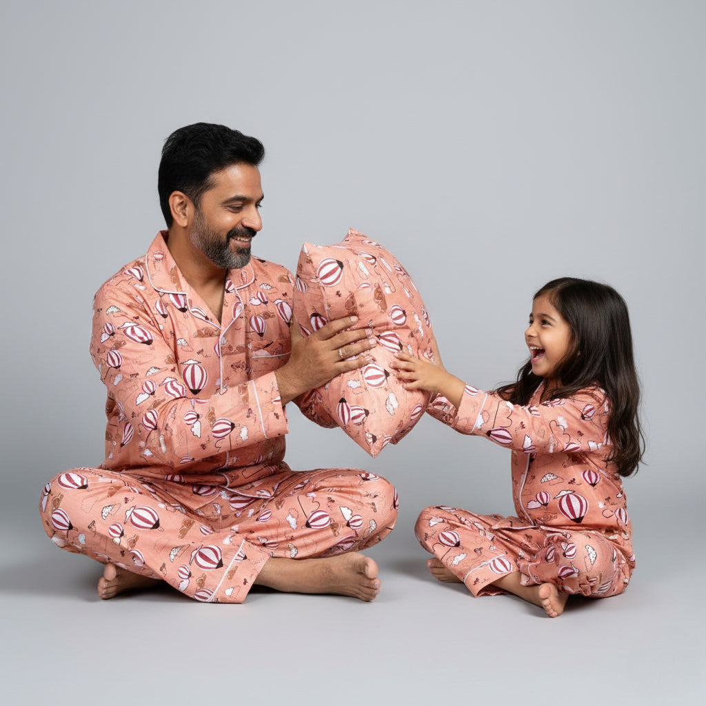 Father and daughter wearing hot air balloon in clouds matching pajamas, light blue coordinated print.
