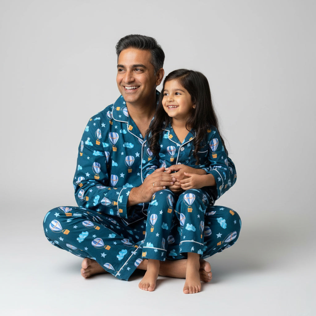 Father and daughter in hot air balloon print matching pajamas, coordinated sky-themed design.