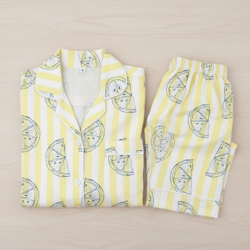 Yellow and white striped pajama set with lemon pattern on a beige background