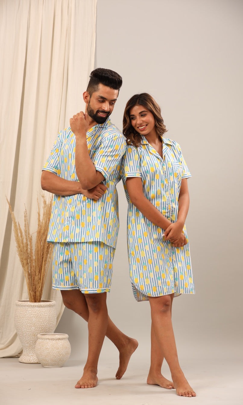 Husband and wife wearing matching blue and yellow patterned pajamas.