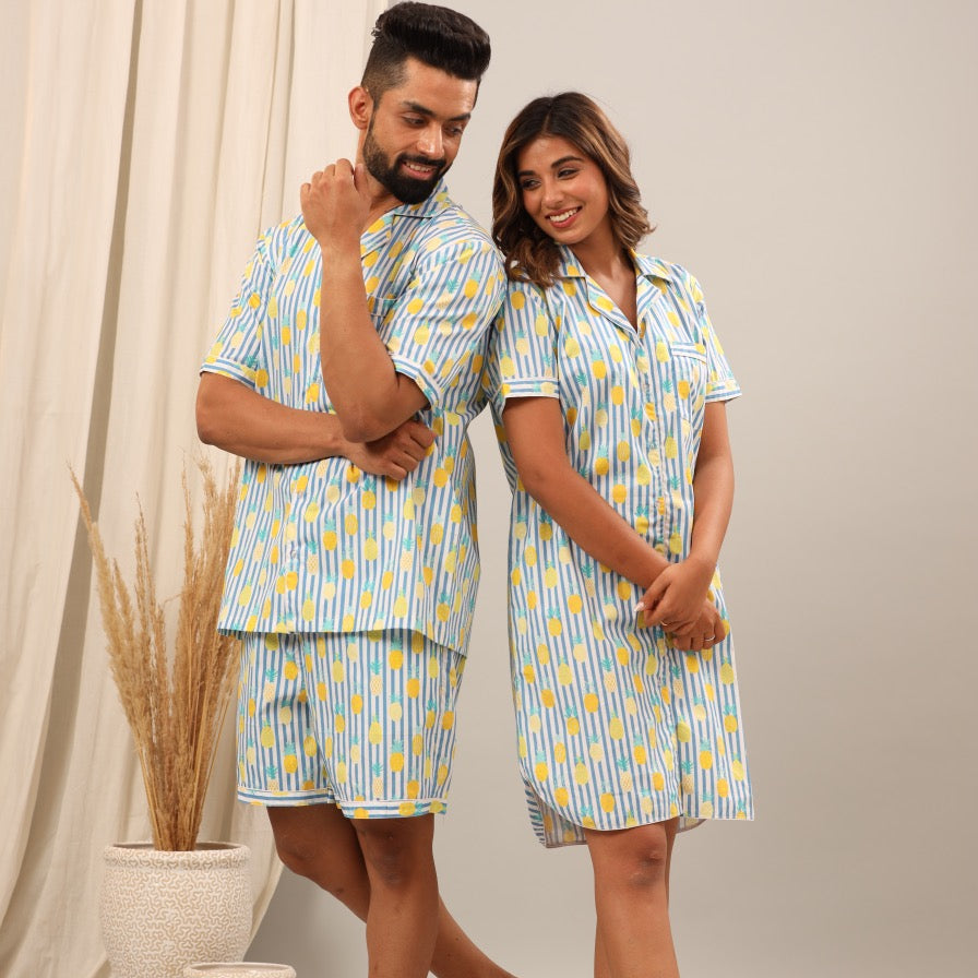 Husband and wife wearing matching blue and yellow patterned pajamas.