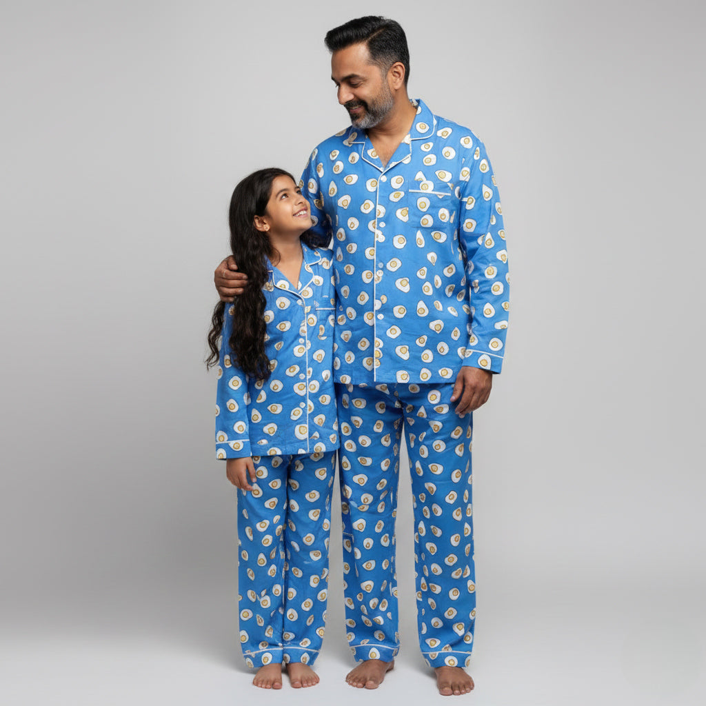 Father and daughter in Omelette Fry matching pajama set, quirky breakfast-themed print.