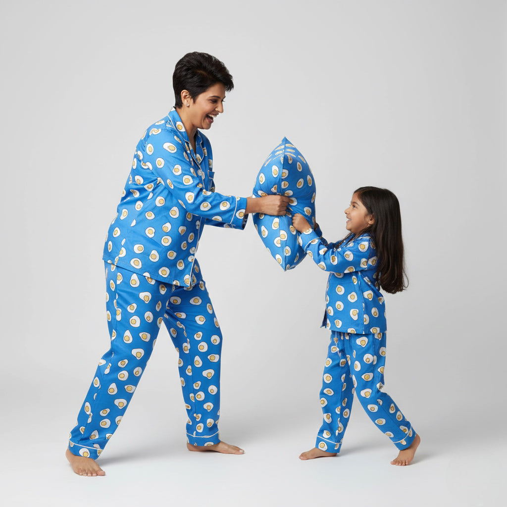 Mother and daughter wearing omelette fry matching pajamas, quirky breakfast-themed print.