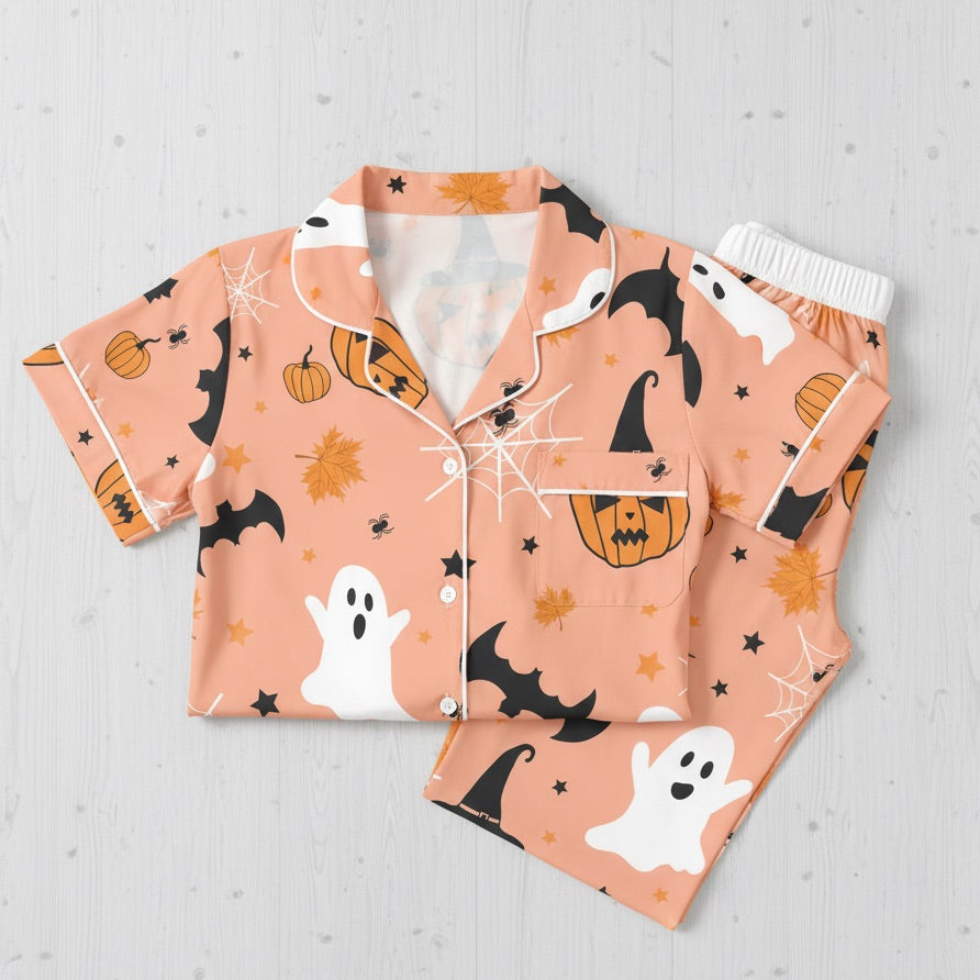 Halloween-themed pajama set with ghosts, pumpkins, and bats on a light gray background