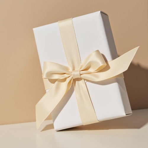 White gift box with a beige ribbon on a beige background