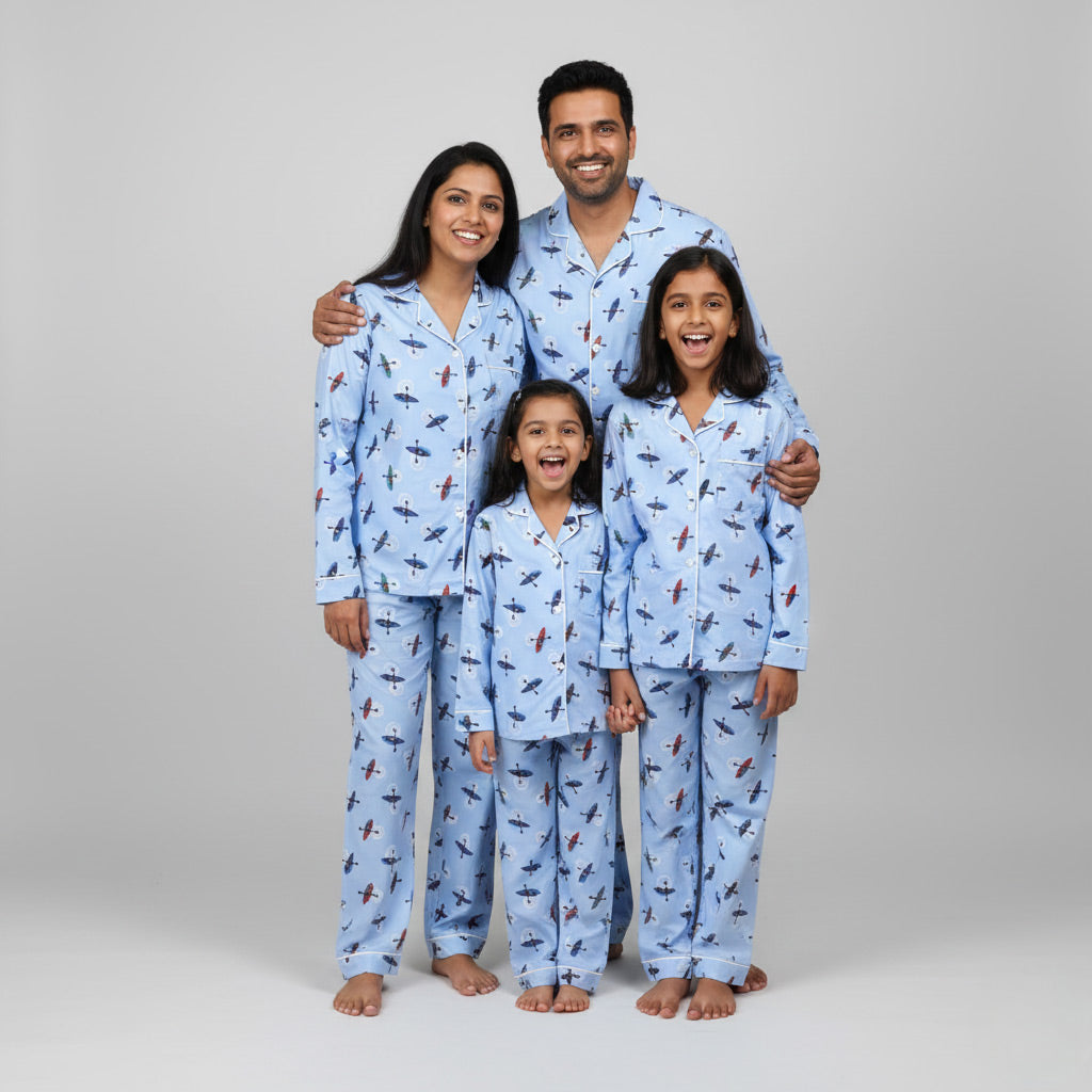 Family wearing rowing boat print matching pajamas, posing together in coordinated outfits.