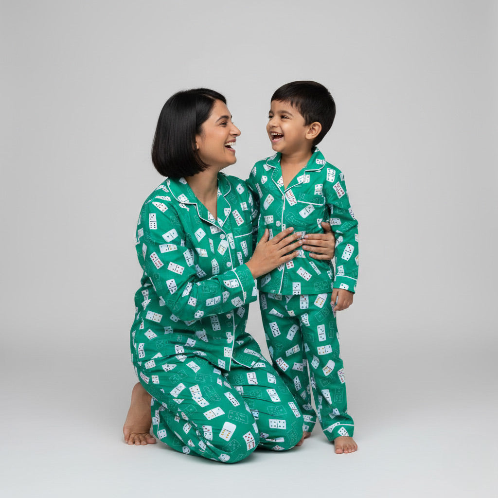 Woman and child wearing matching green pajamas with a pattern on a gray background