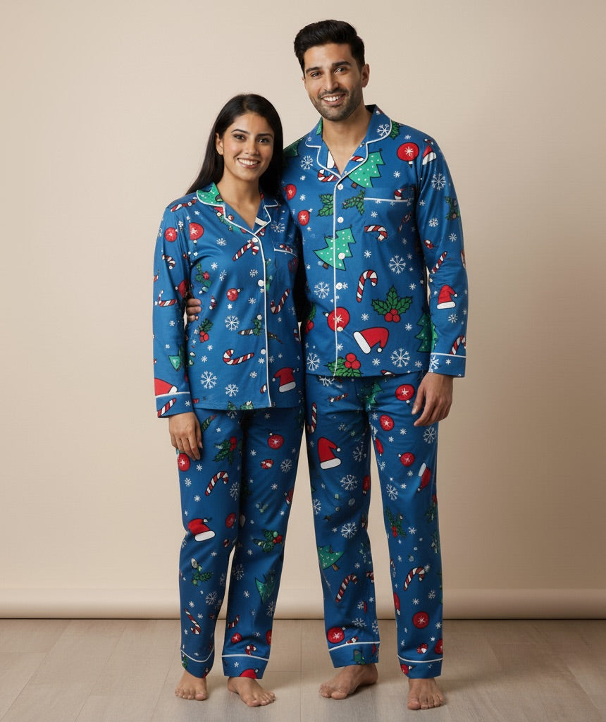Man and woman wearing matching blue Christmas pajamas against a beige background