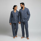 Matching couple pajamas in classic navy double stripe cotton.