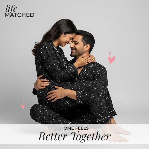 Couple wearing matching black pajamas, sharing a warm and intimate moment at home