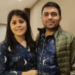 Couple wearing matching pajamas with celestial designs indoors