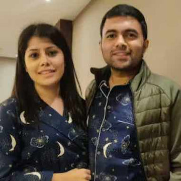 Couple wearing matching pajamas with celestial designs indoors
