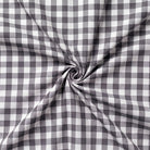 Close-up of gray and white checkered fabric with a swirl pattern.