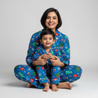 Woman and child wearing matching blue Christmas pajamas on a gray background