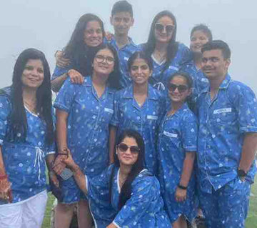 Group of people wearing matching blue pajamas with a misty background