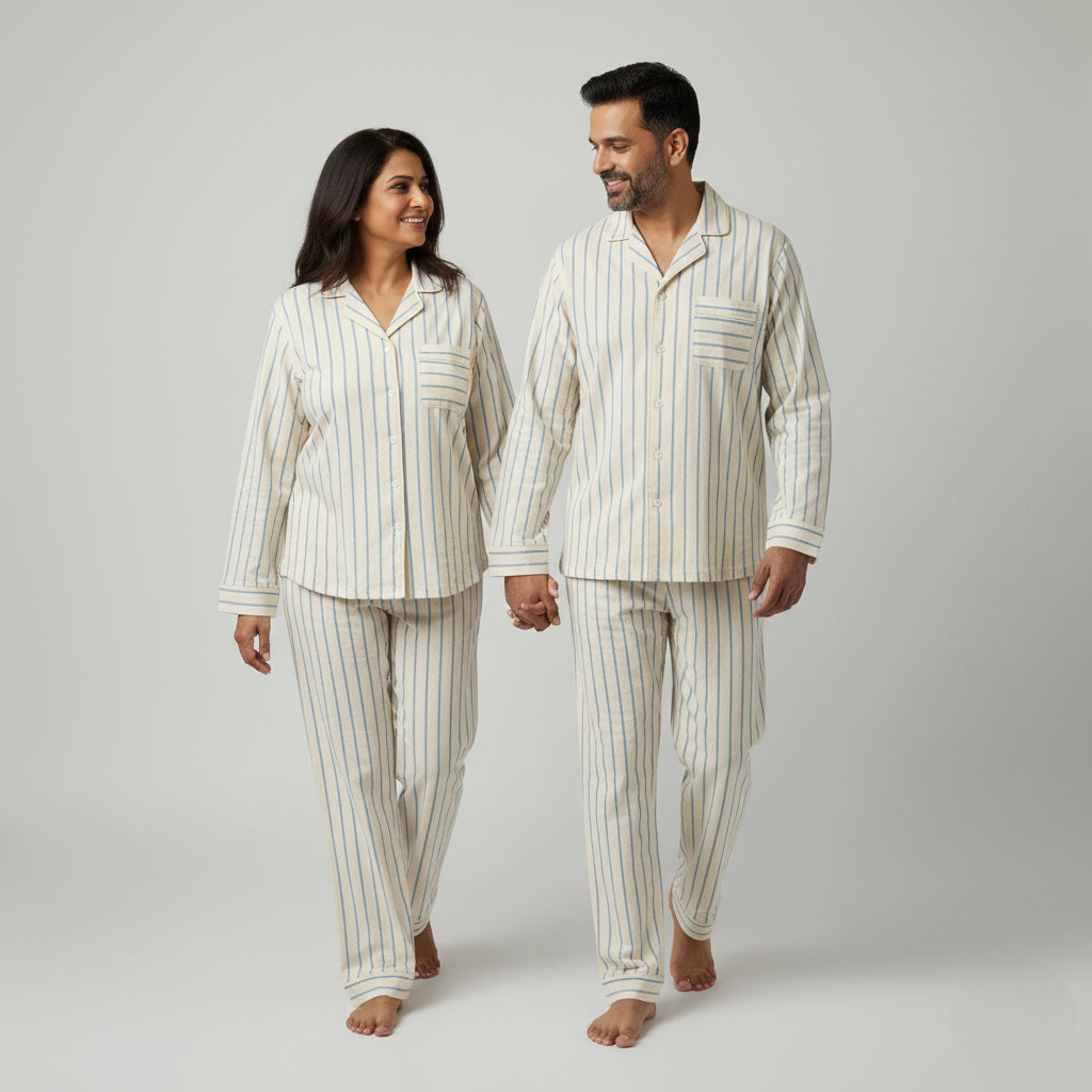 Matching couple cotton pajamas in ivory cream with blue stripes.