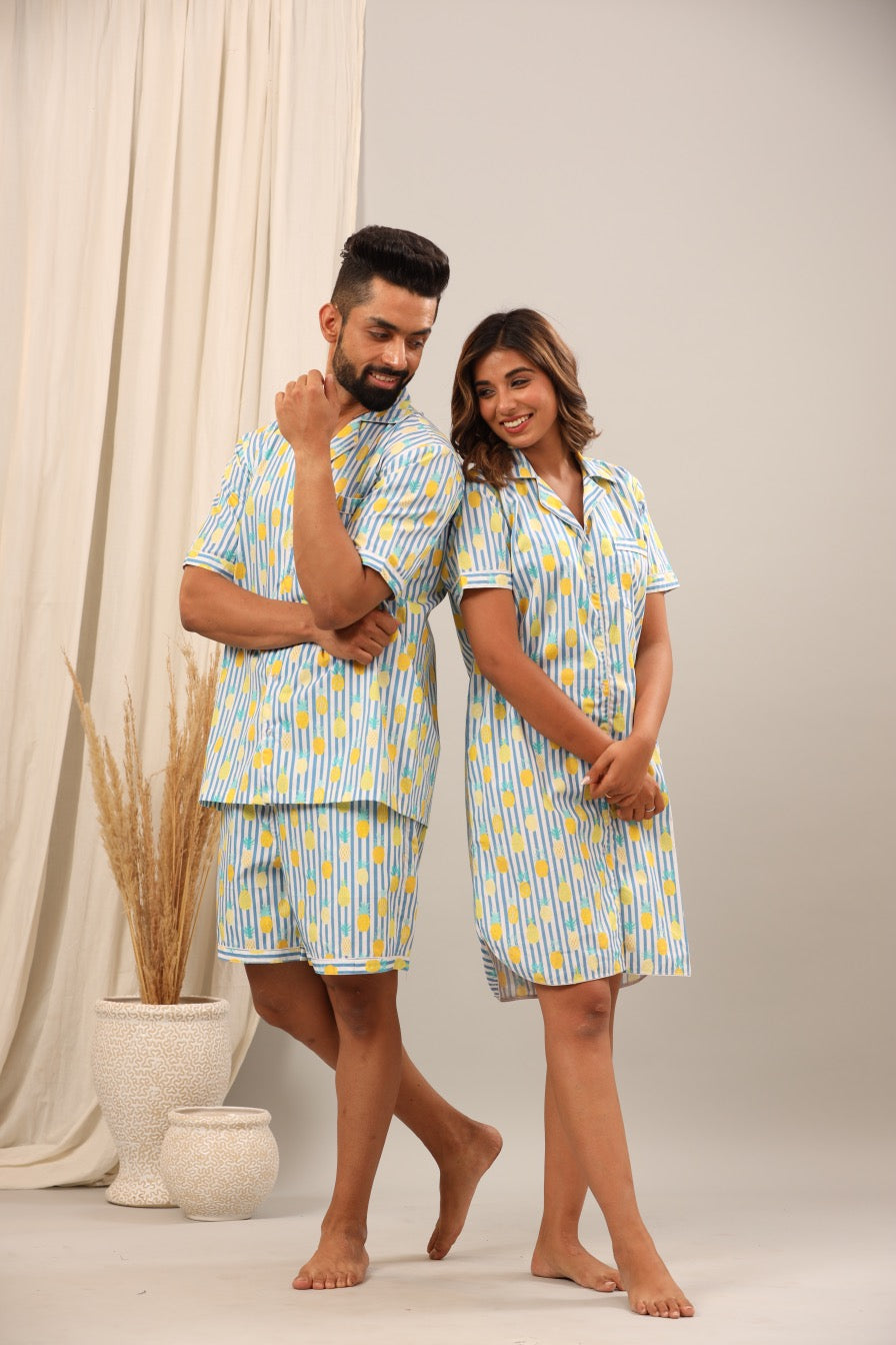 Husband and wife wearing matching blue and yellow patterned pajamas.