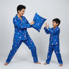 Woman and child in matching blue pajama sets with a pillow fight on a white background