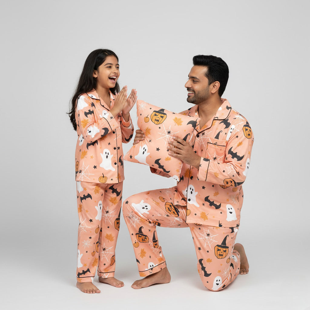 Father and daughter in Pumpkin Tricksters matching pajama set, Halloween-themed coordinated print.