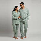 Matching couple nightwear in sage green and ivory stripes.