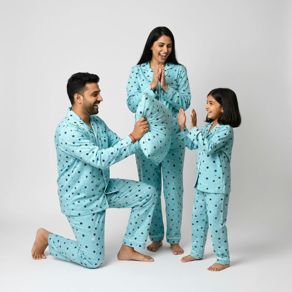 Family in twinkling stars matching pajamas, posing happily in coordinated nightwear.